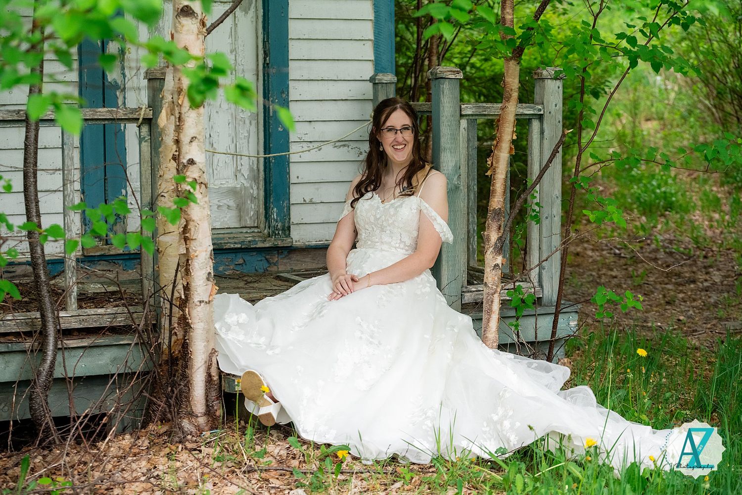 Beautiful white wedding dress captured in a rustic outdoor setting with birch trees and green foliage.