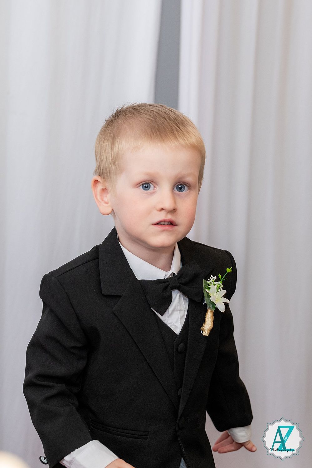 Four linked photos showing a young child in a formal black suit and tie with a floral boutonniere against a light background.