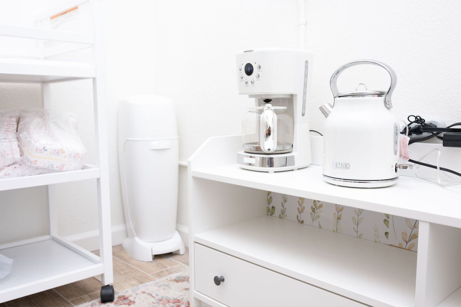 White kitchen counter with coffee maker, electric kettle and small appliances.