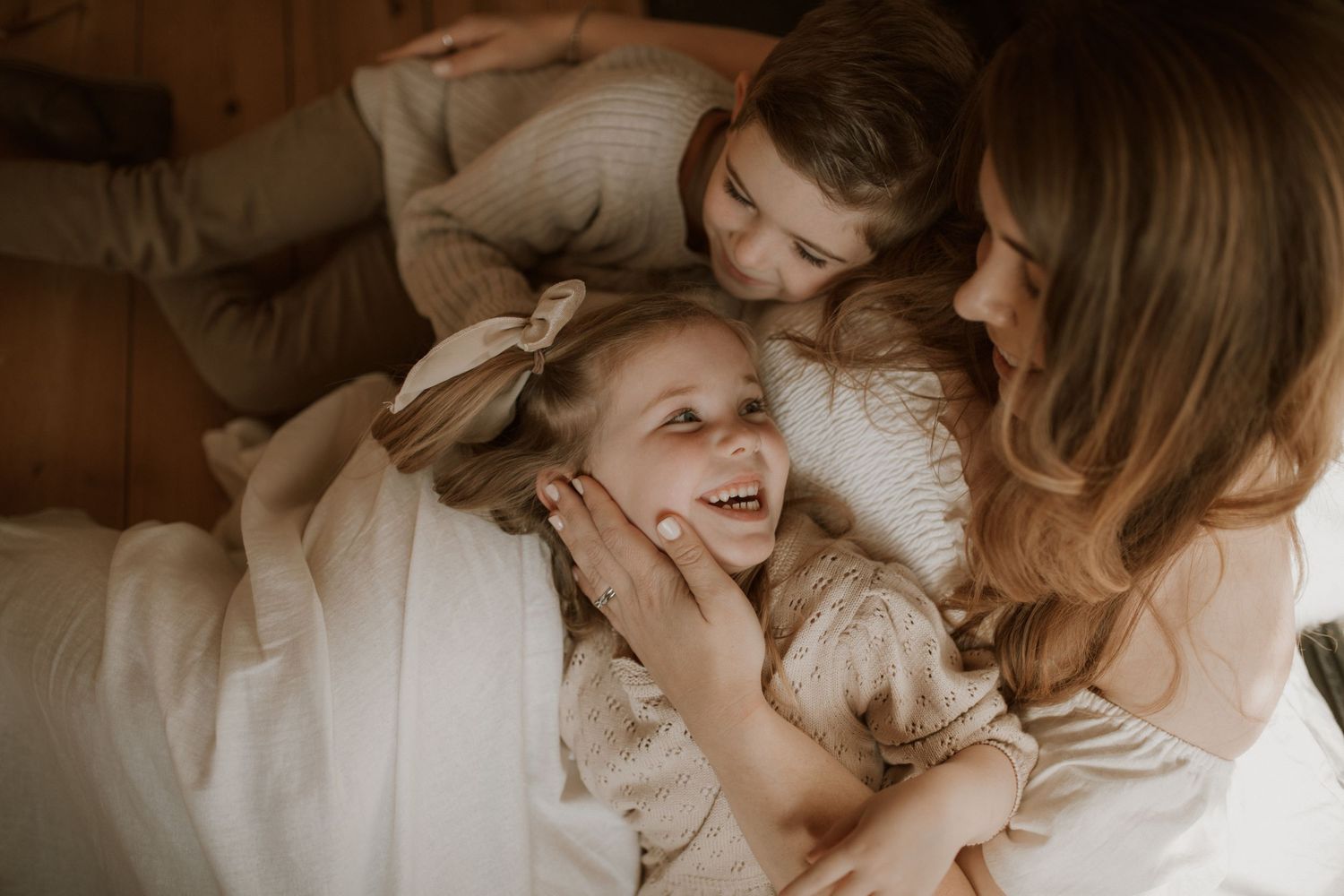 A parent lovingly kisses a small child while holding them in a tender embrace during a joyful moment together.