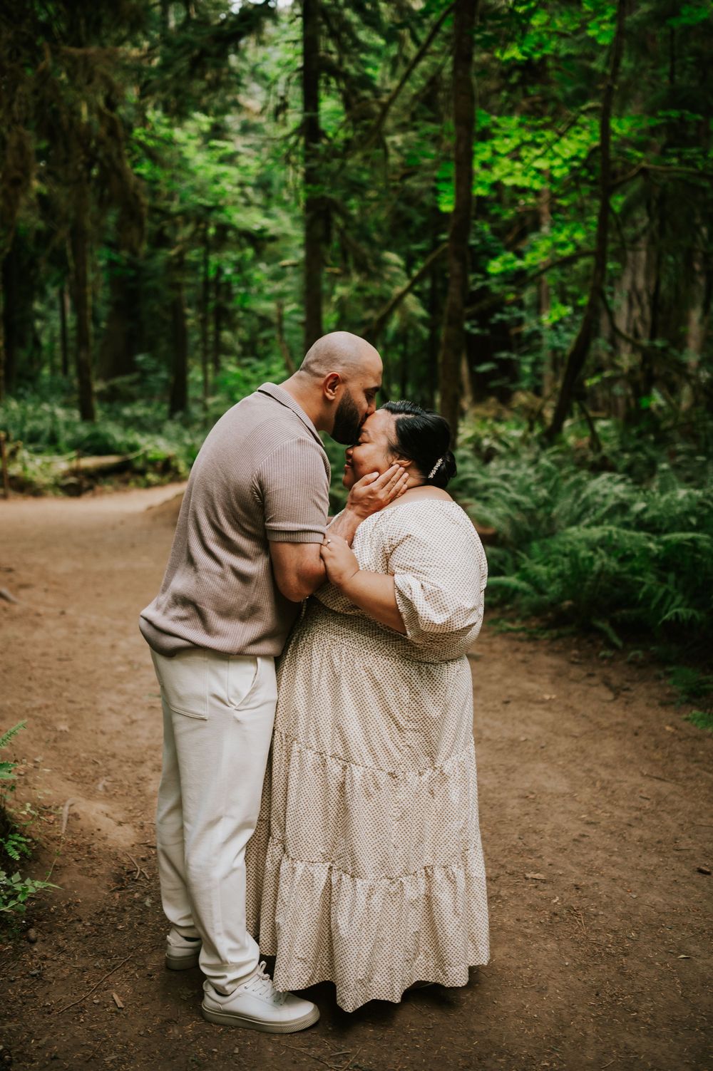 Photography of engaged couple kissing foreheads in Cathedral Groves, MacMillan Park forest. Vancouver Island adventure photographer