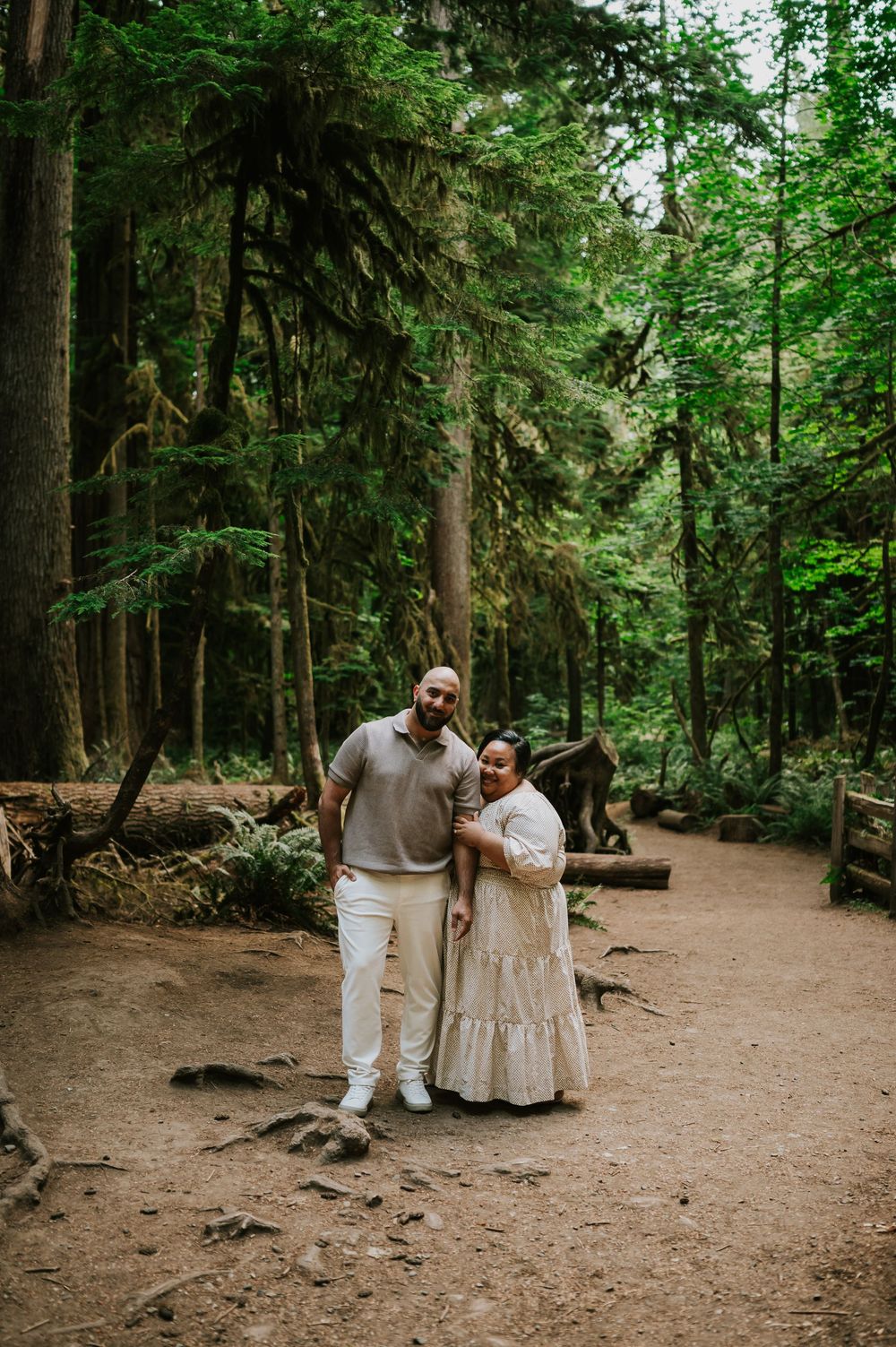 Portrait of engaged couple smiling in Cathedral Groves, MacMillan Park fir tree forest. Vancouver Island adventure photographer