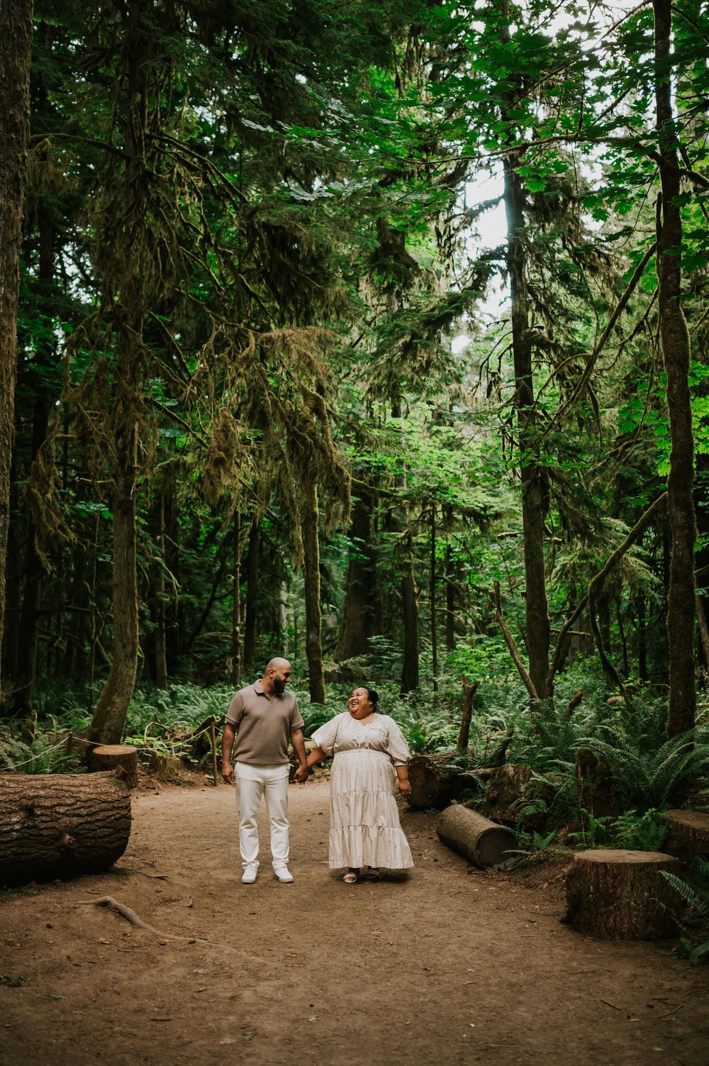 Photography of engaged couple walking holding hands in Cathedral Groves, MacMillan Park forest. Vancouver Island adventure photographer