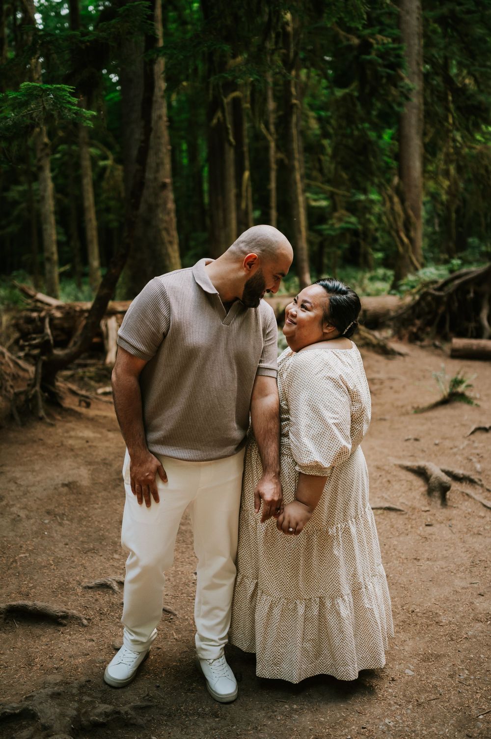 Romantic portrait of engaged couple smiling in Cathedral Groves, MacMillan Park forest trails. Vancouver Island adventure photographer