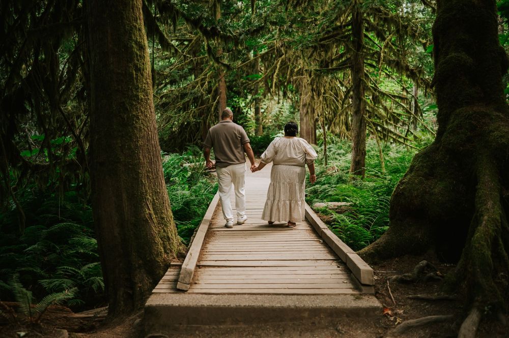 Romantic portrait of engaged couple walking in Cathedral Groves, MacMillan Park forest trails. Vancouver Island adventure photographer