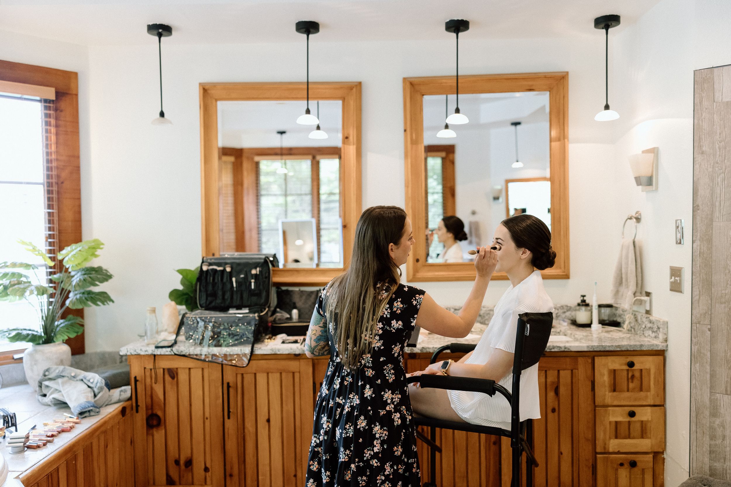 A beauty service being performed at a rustic wooden salon station with pendant lights and indoor plants.