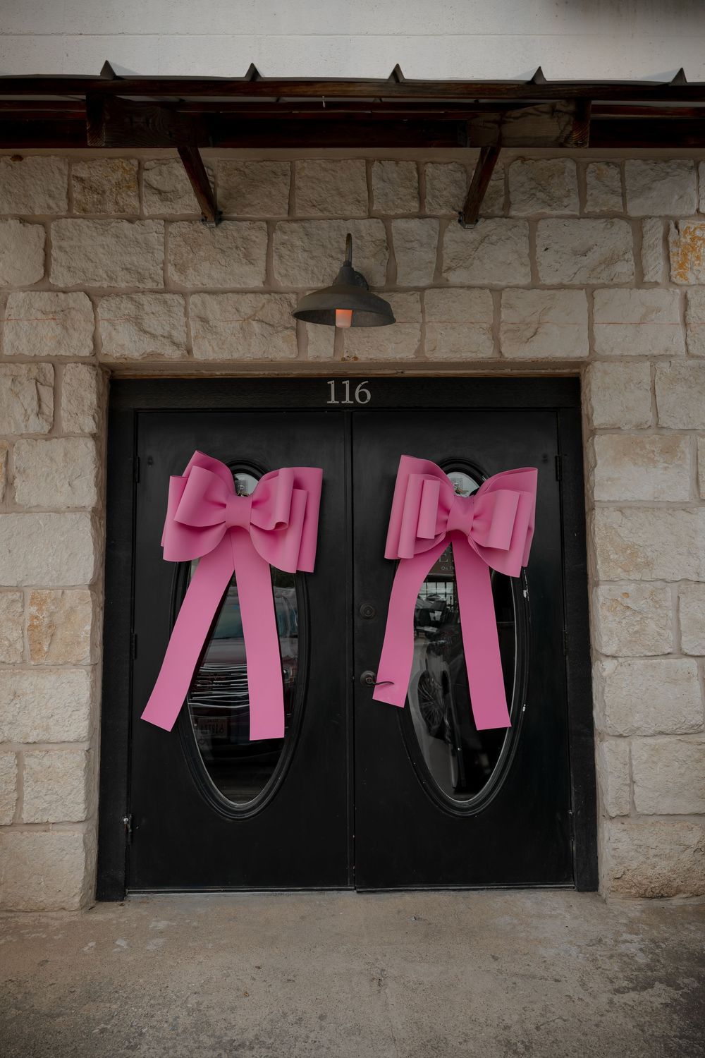 Venue entrance doors decorated with large pink bows at Fort Worth baby shower