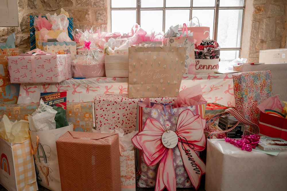 Pink baby shower gift table with wrapped presents and bows at a Dallas–Fort Worth celebration in Parker County