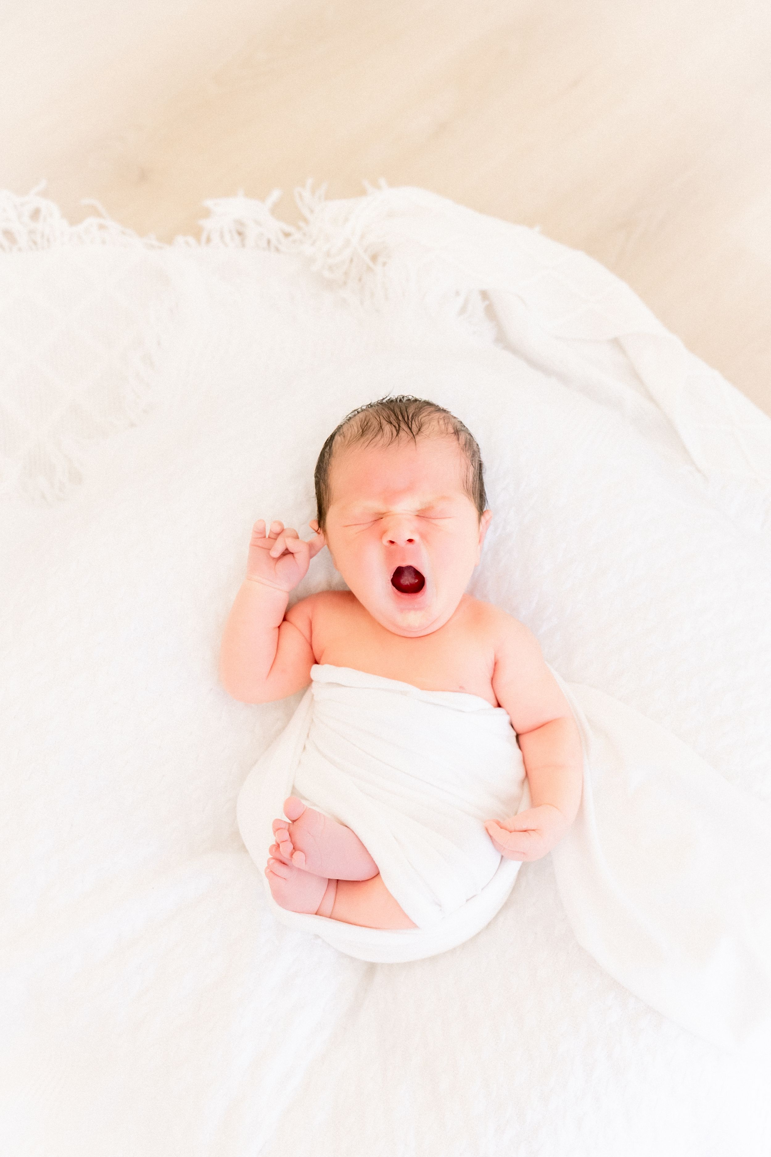 baby yawns during his newborn session in largo florida photoshoot