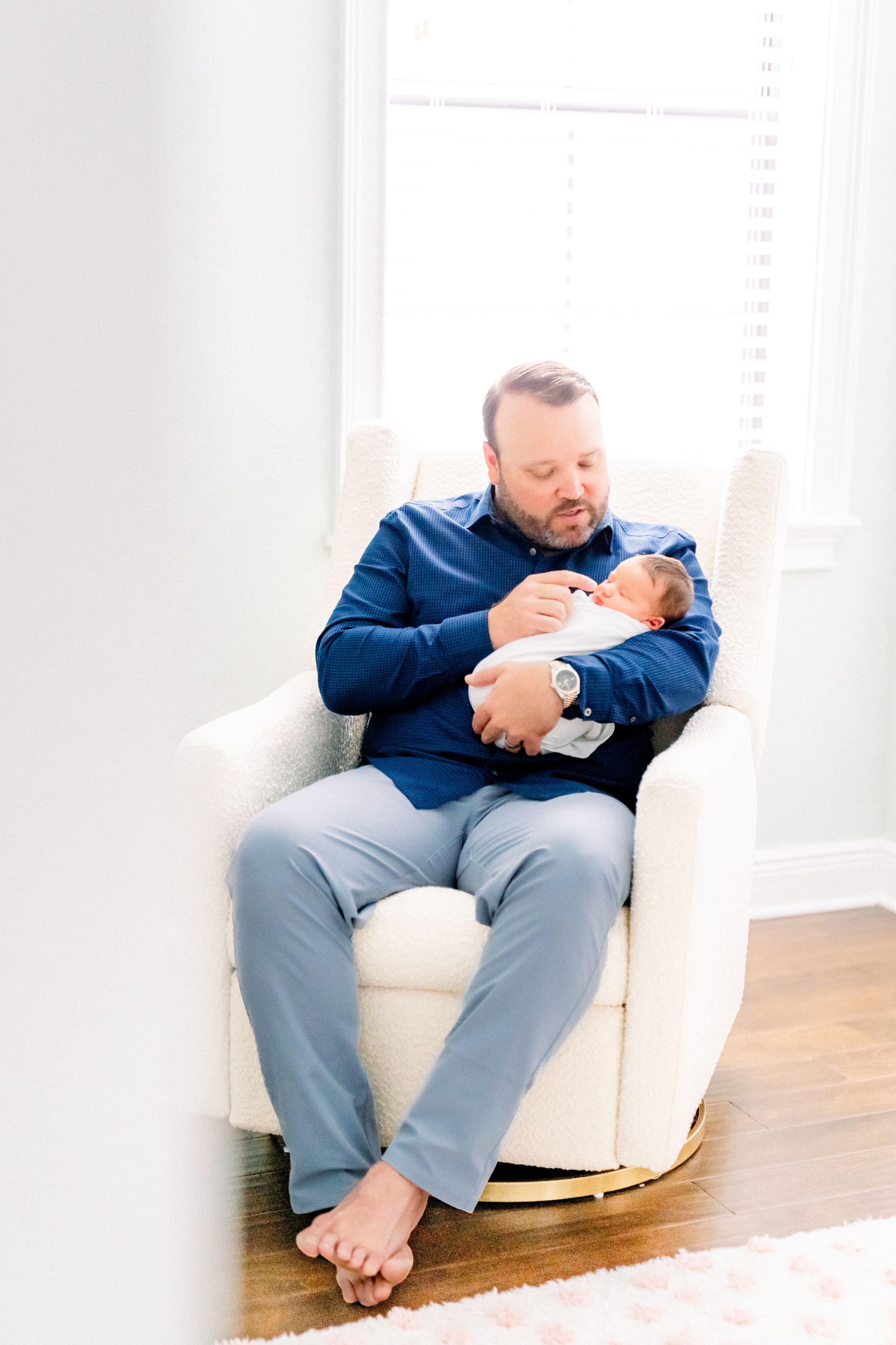 dad holding his baby girl in her nursery during their baby photography session in Tampa florida