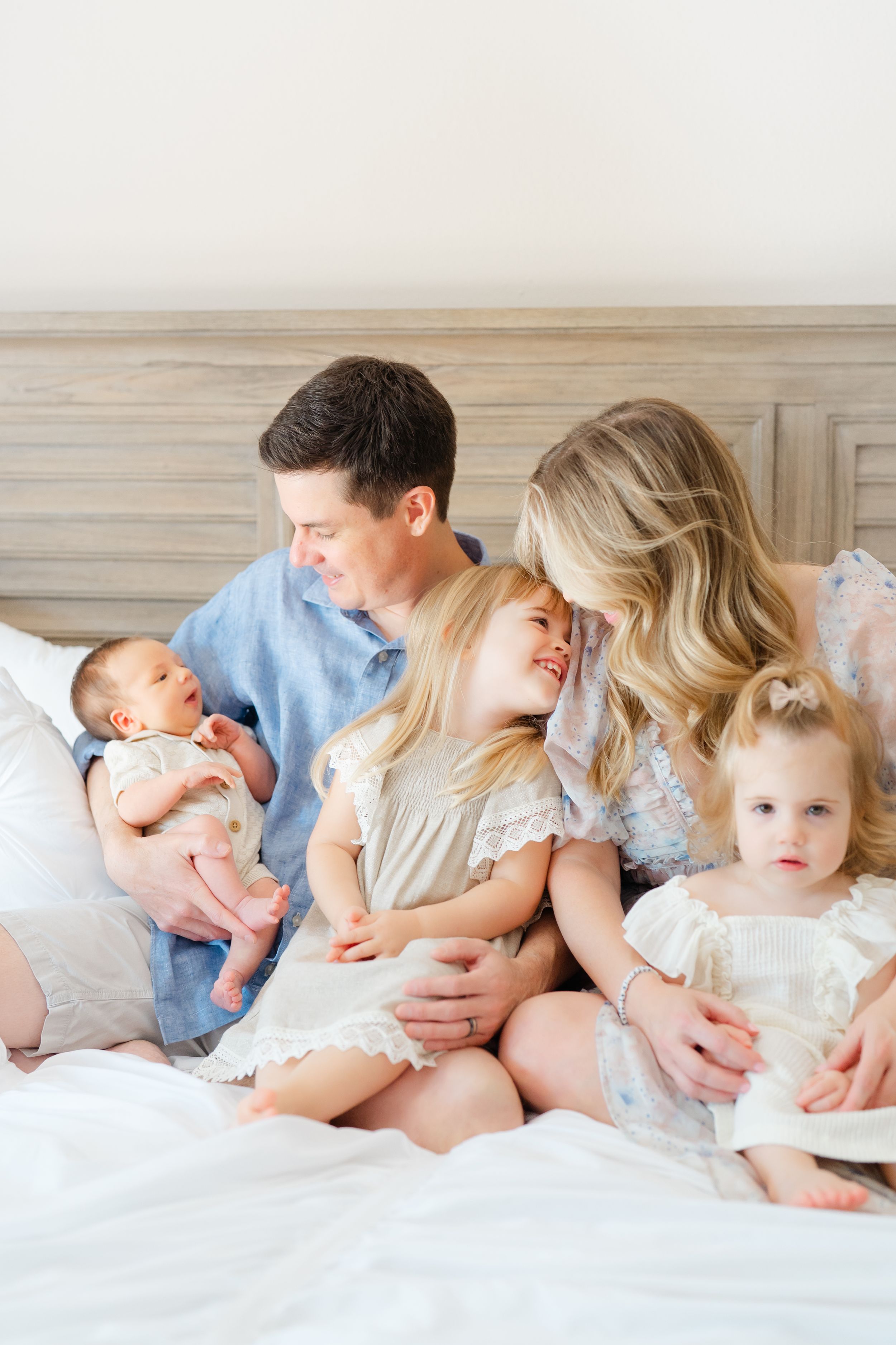 family snuggling on a bed during a newborn session in Tampa florida
