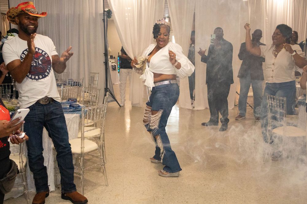 People dancing at a party with fog machine effects in a decorated event venue.