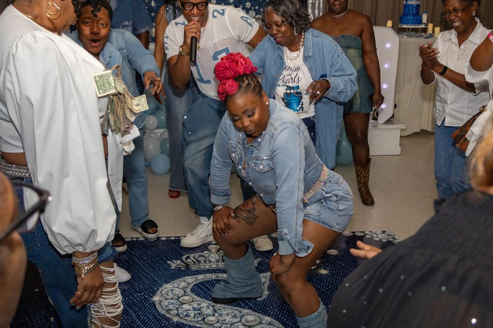 People in denim outfits dancing and celebrating at a lively indoor party event.
