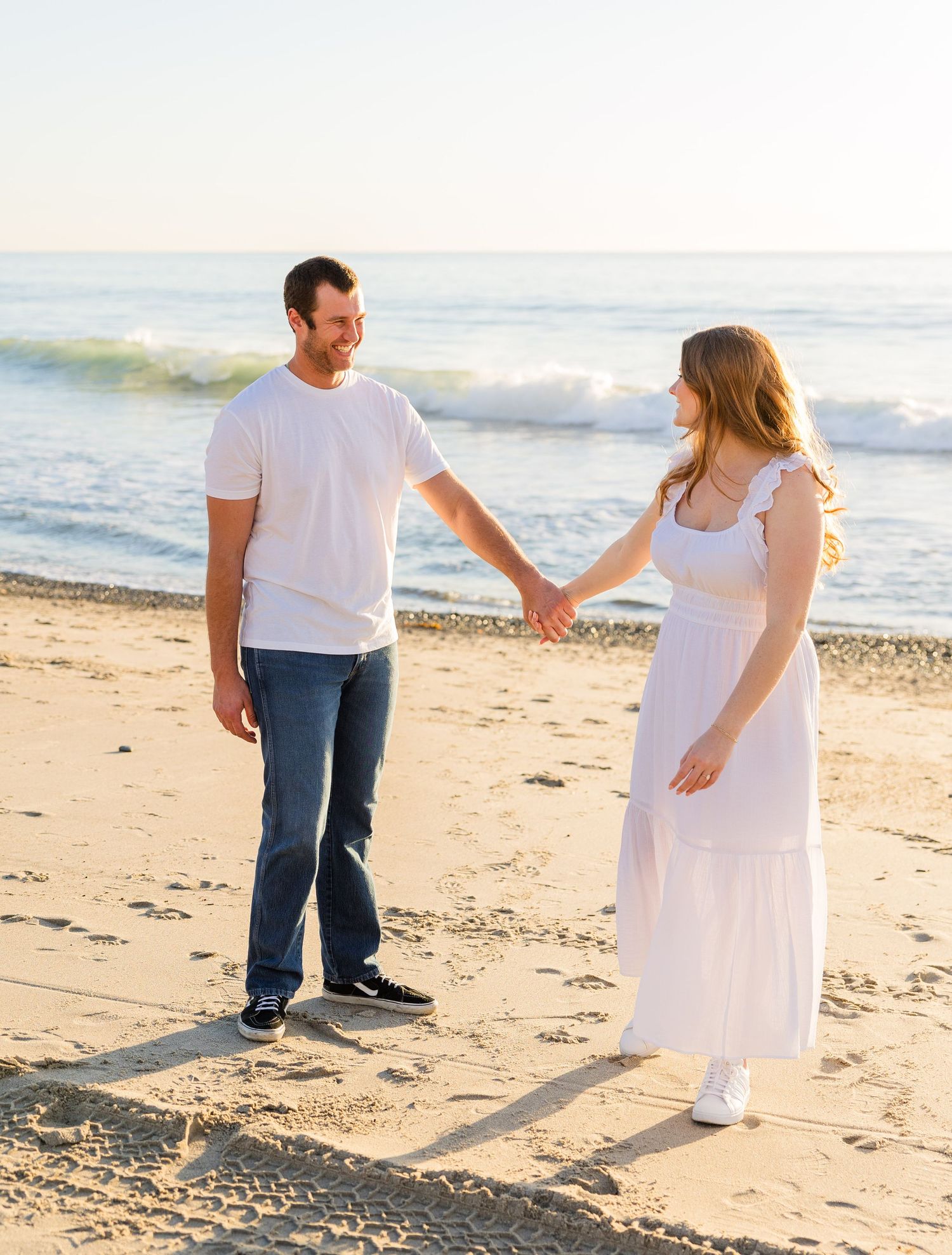 Engaged couple walking on Califia beach in San Clemente