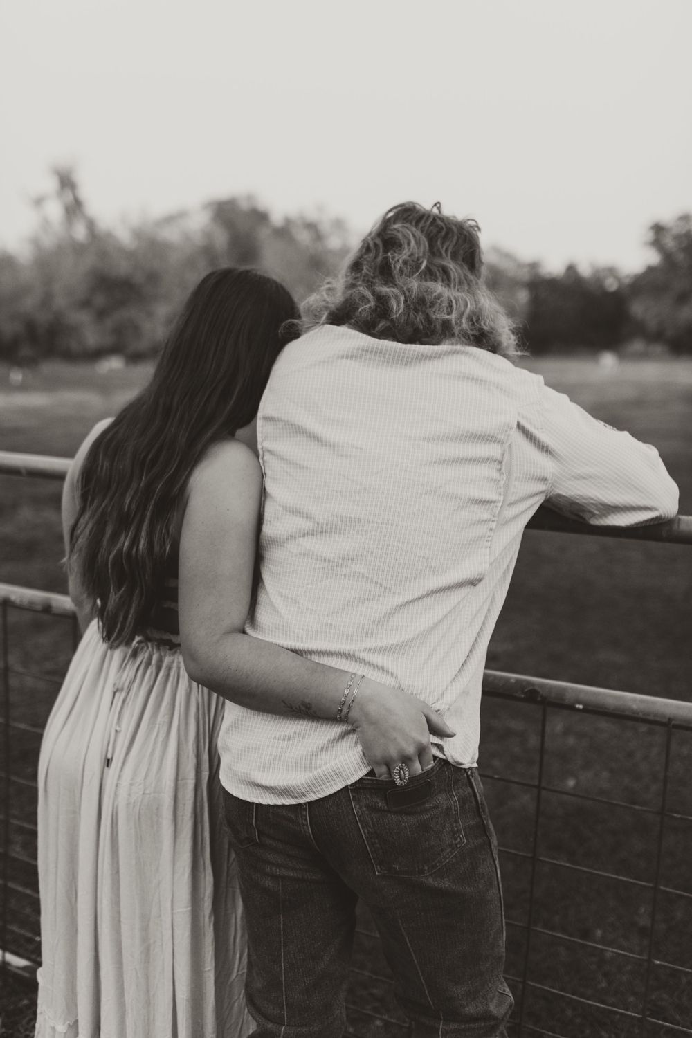 Silhouetted couple embracing against a fence in a series of intimate black and white photos.