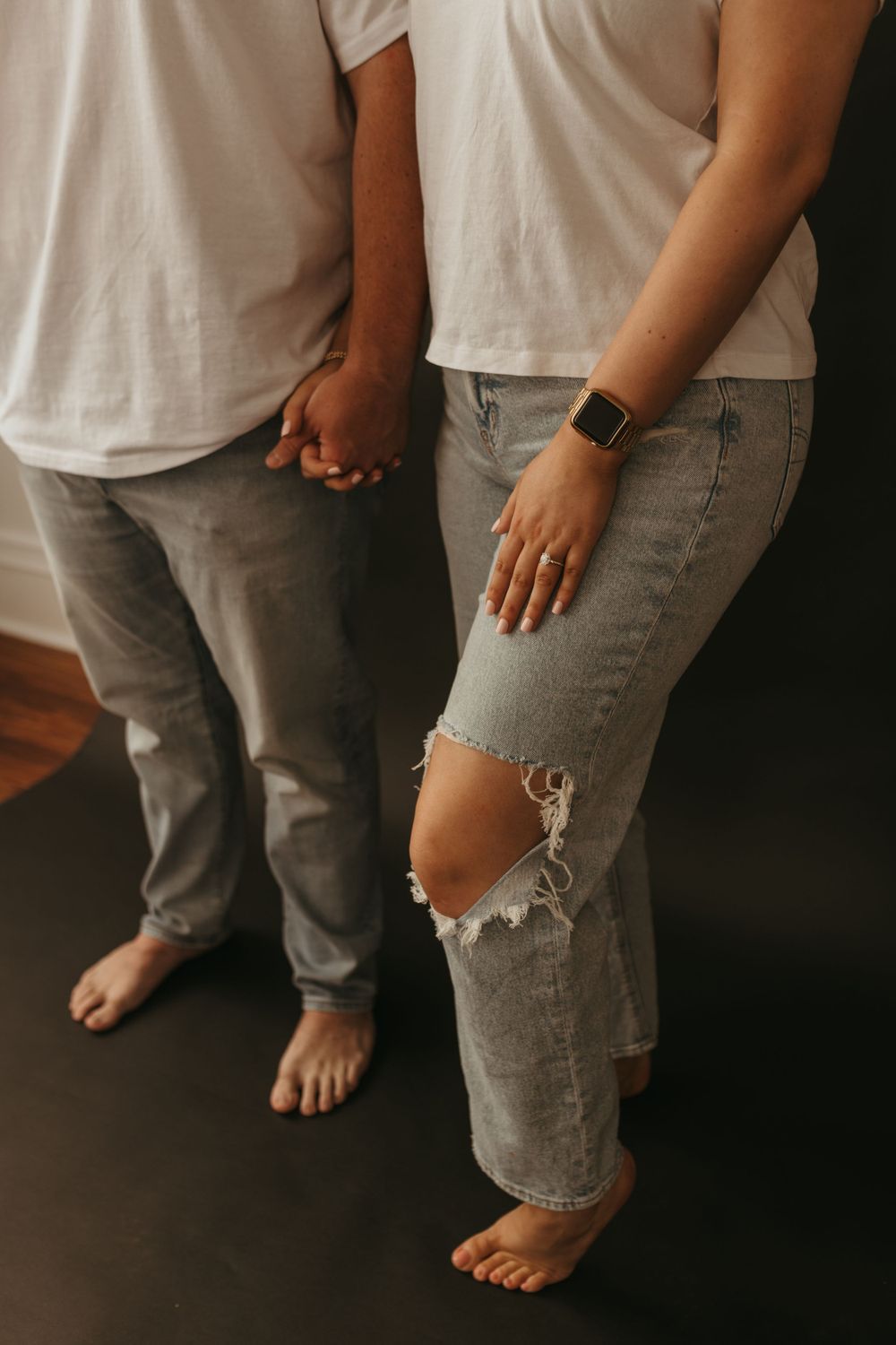 Close-up of two people in matching outfits standing barefoot together.