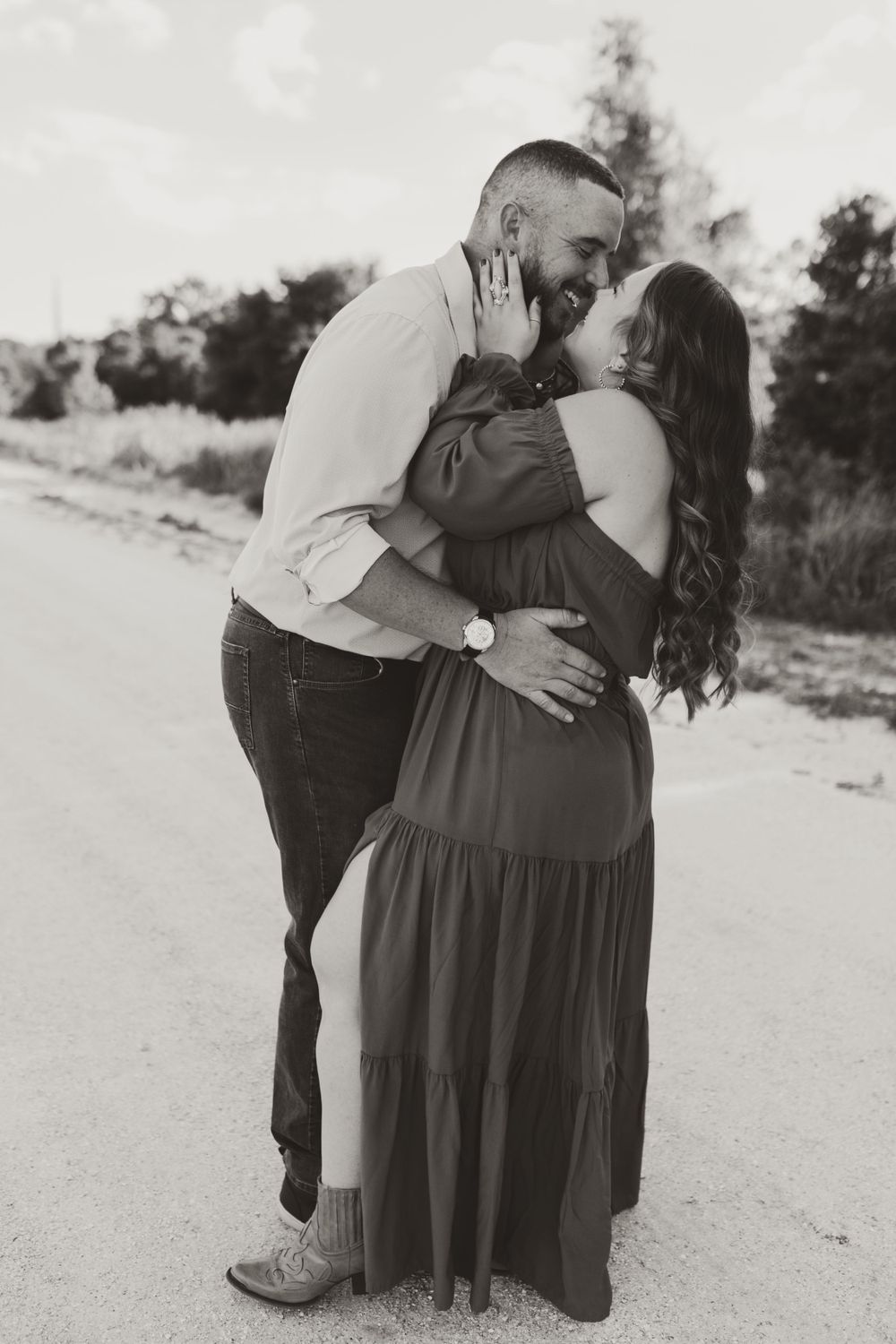 Black and white photography sequence showing tender moments between a couple on a dirt path.