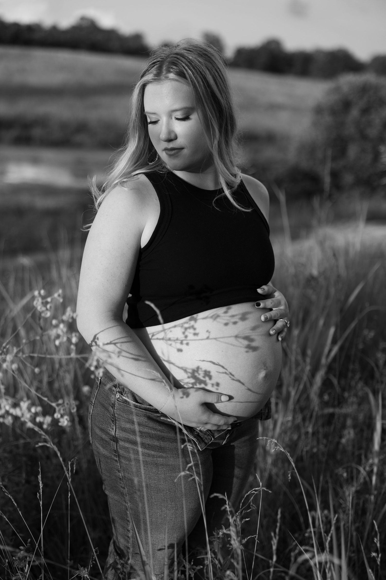 A maternity photo featuring a blue ruffled dress with a sweet moment captured outdoors.
