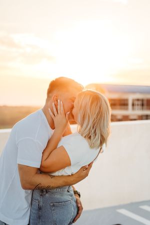 Romantic couple embracing at sunset on a rooftop parking lot in Hartford, CT.