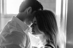 Intimate black and white portrait of couple in tender embrace by window light Branford, CT.
