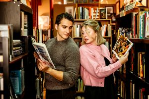 Two people share an intimate moment while browsing books in a dimly lit library Hamden, CT.