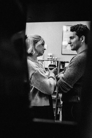 A black and white photo captures an intimate moment between two people in a library Hamden, CT.