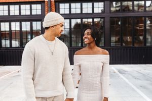 Couple in matching white sweaters sharing a sweet moment outdoors in Waterbury, CT.