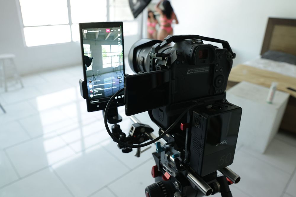 Professional camera setup with smartphone mounted on tripod and video accessories for content creation.
