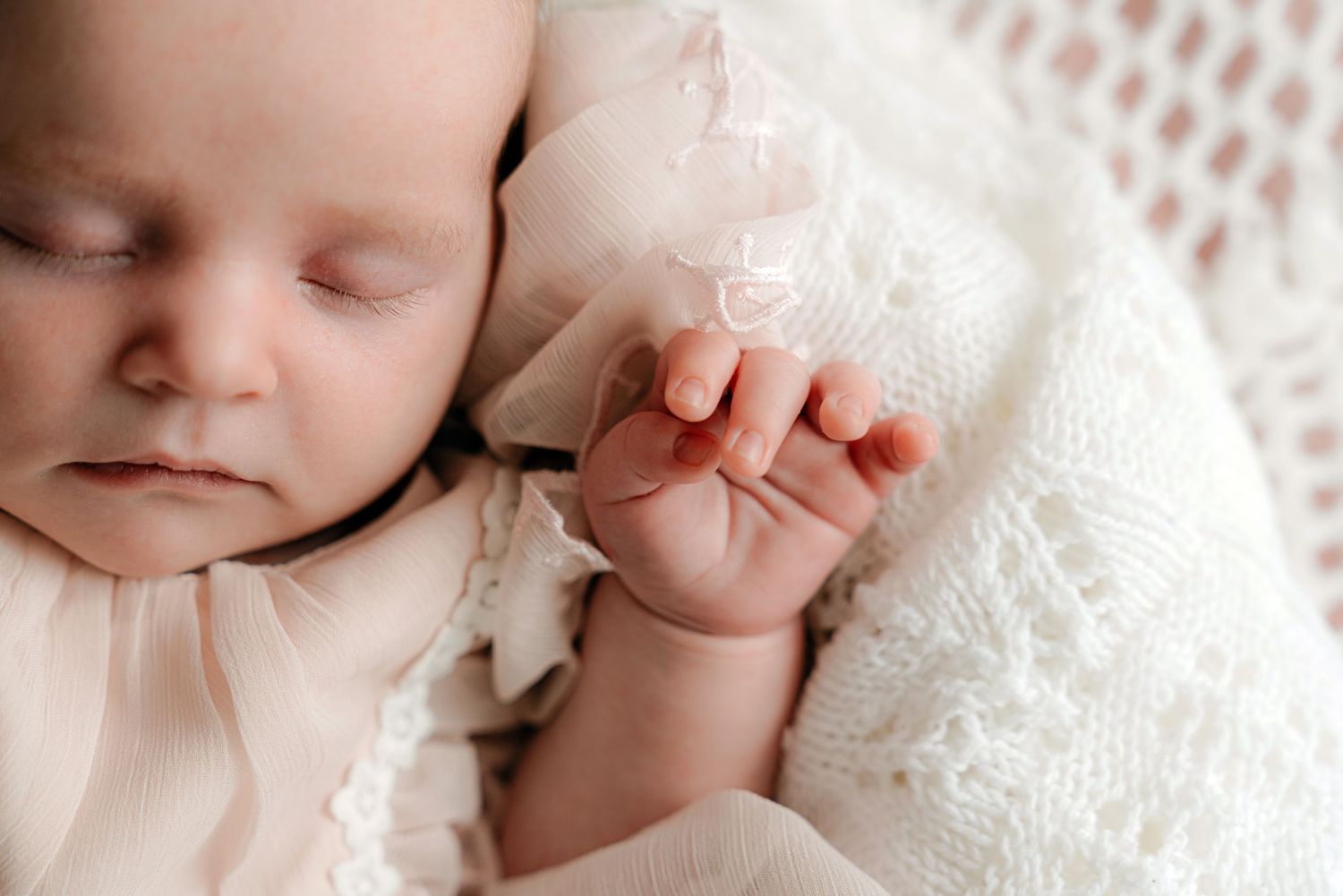 Delicate close-up shots of a sleeping baby wrapped in white lace.