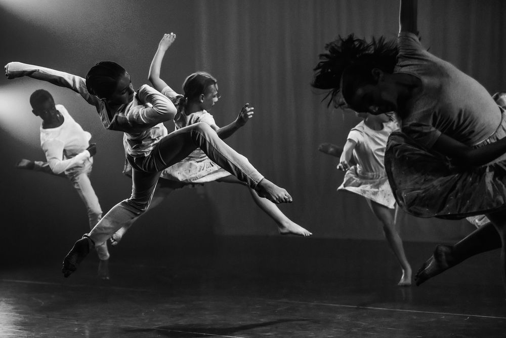verschillende dansers in volle sprong tijdens een dansvoorstelling als performers