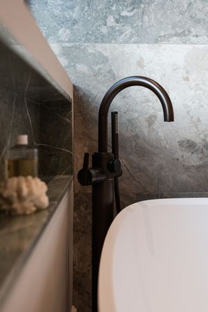 Modern bathroom interior featuring sleek black faucets and marble countertops with dramatic lighting effects.