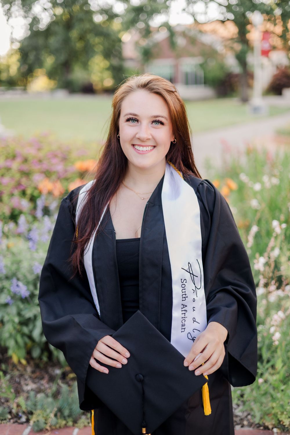 santa rosa junior college SRJC graduate, college senior. senior photos in Sonoma County, California. cap and gown near flowers.