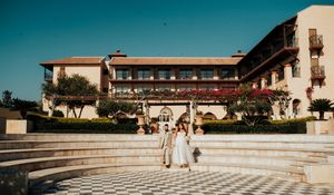 A panoramic view of a Spanish colonial style courtyard with checkerboard tile flooring and arched walkways.