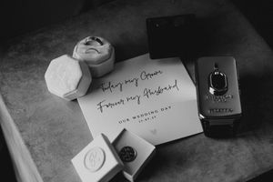 Elegant wedding stationery and place cards arranged on a dark surface with calligraphy writing.
