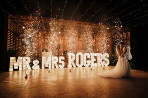 Illuminated Mr & Mrs Rogers sign with sparklers and dance floor at wedding reception venue.