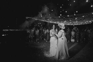 A string of twinkling lights creates a romantic canopy over an outdoor nighttime wedding reception.
