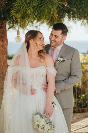 A happy couple shares intimate moments outdoors on their wedding day in a series of candid shots.