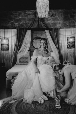 A series of black and white photos showing a bride in a flowing white dress relaxing on vintage furniture.