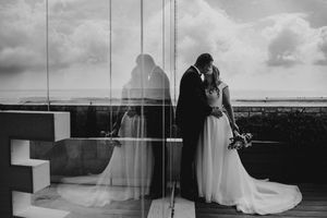 A series of black and white wedding photographs arranged in a horizontal collage showing romantic moments and scenic views.