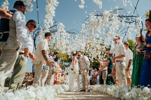 Wedding guests dance and celebrate under a canopy of glowing white crystal decorations at an elegant reception.