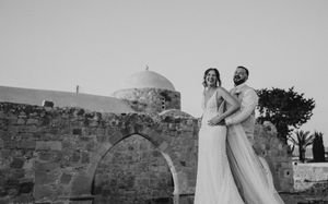 A black and white wedding photo series showing romantic moments between a couple against stone walls and outdoor settings.