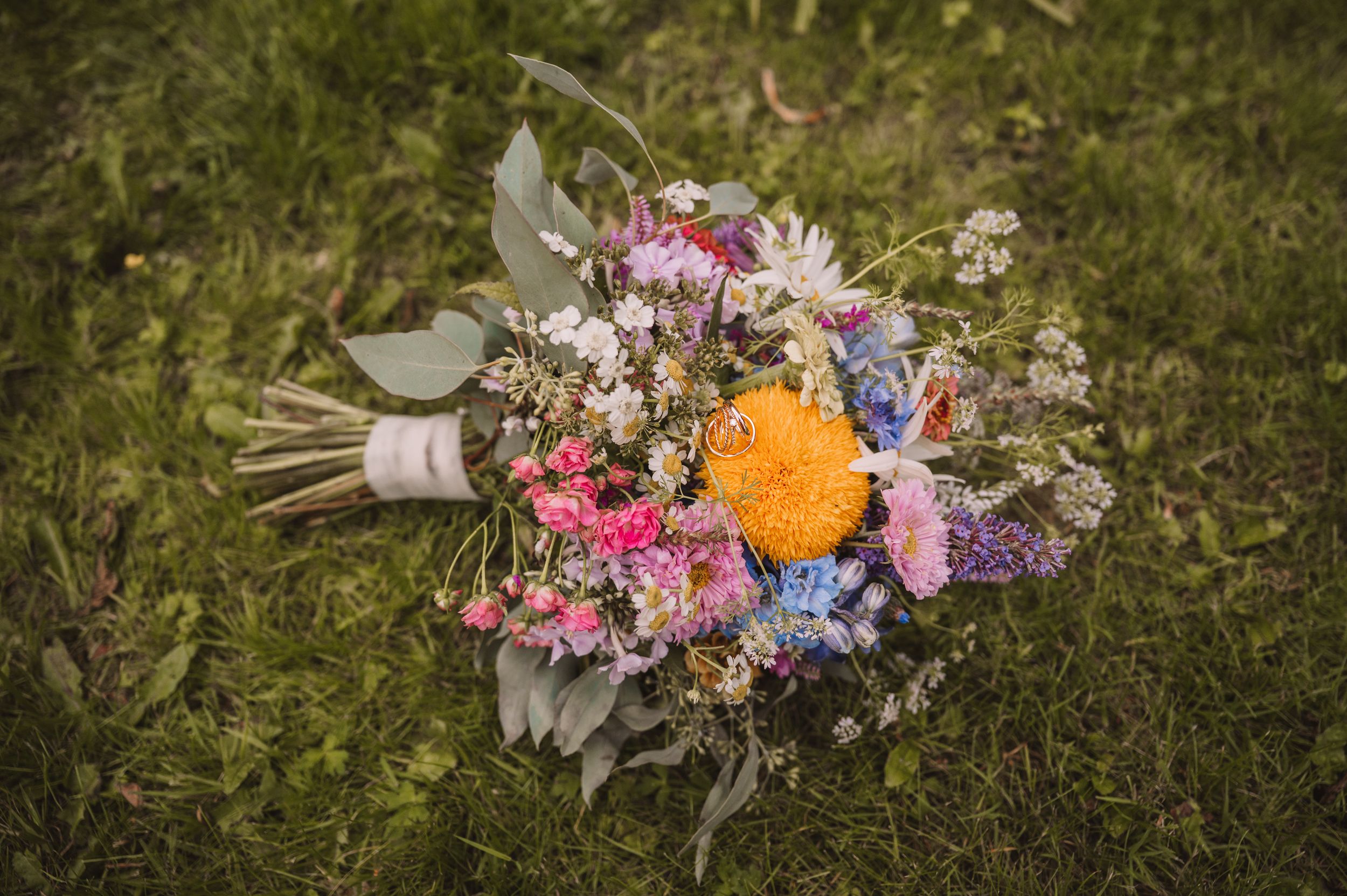 Eheringe und ein Brautstrauß aus Wildblumen