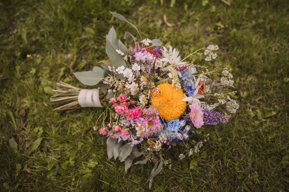 Eheringe und ein Brautstrauß aus Wildblumen