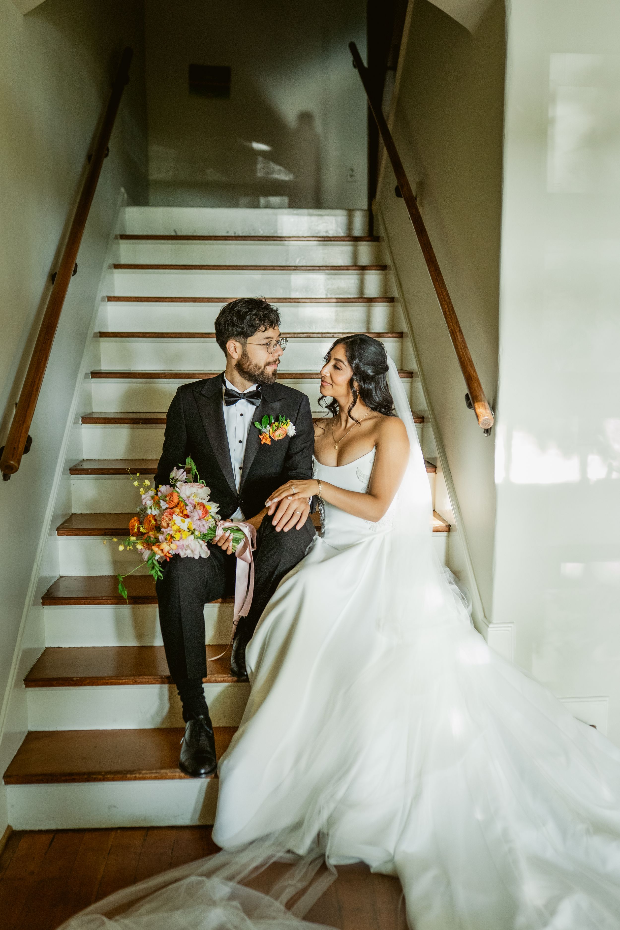 Bride and groom share romantic moments on a white staircase in a series of elegant wedding photos.