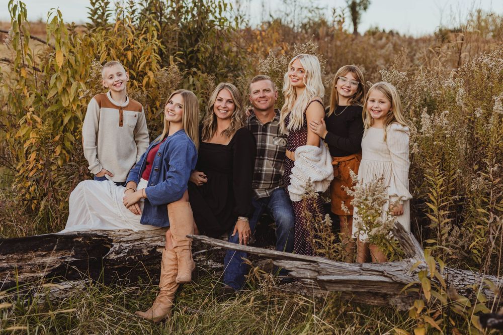 Group photo session in rustic field setting during autumn season.