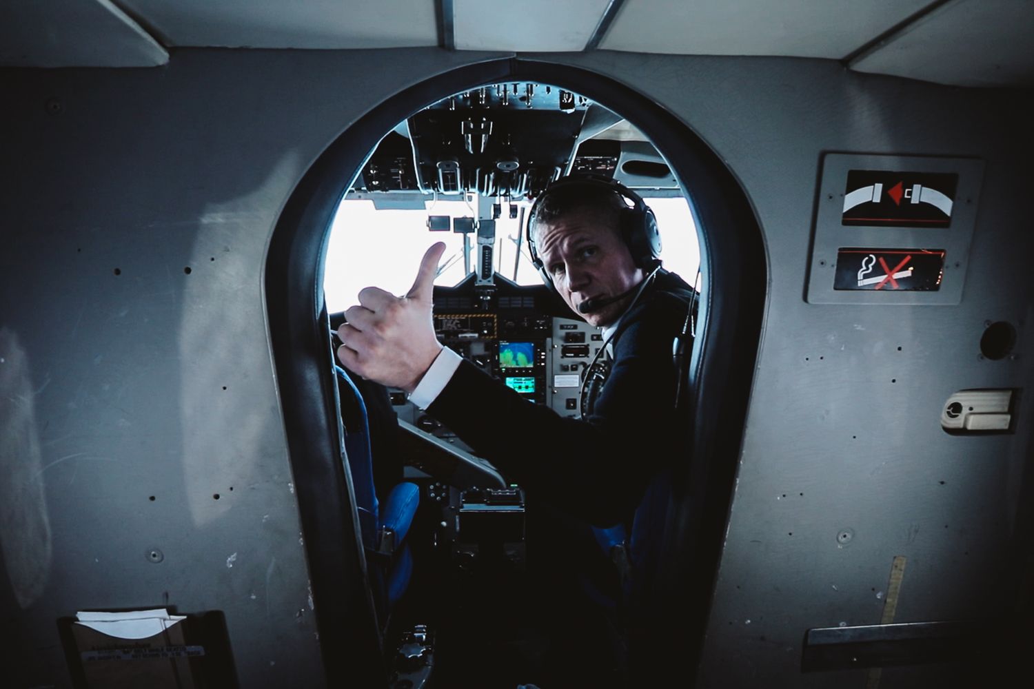 Dark interior view of control room with illuminated displays and equipment.