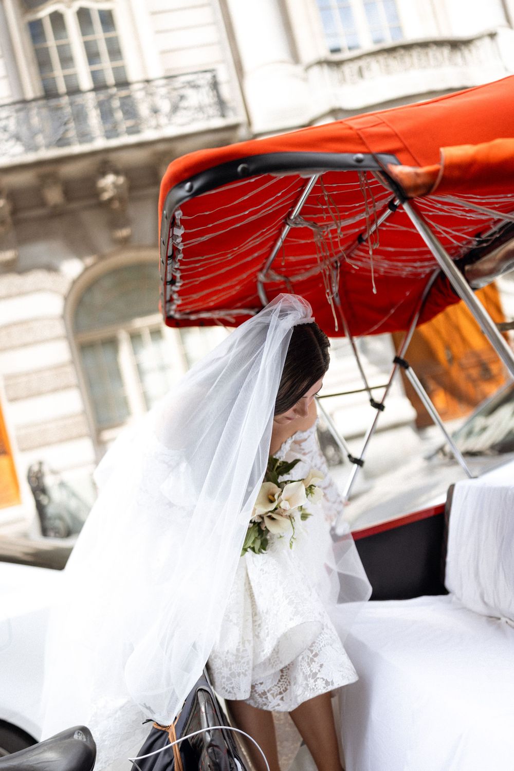 White wedding dress fabric flowing from a red-topped pedicab or rickshaw.