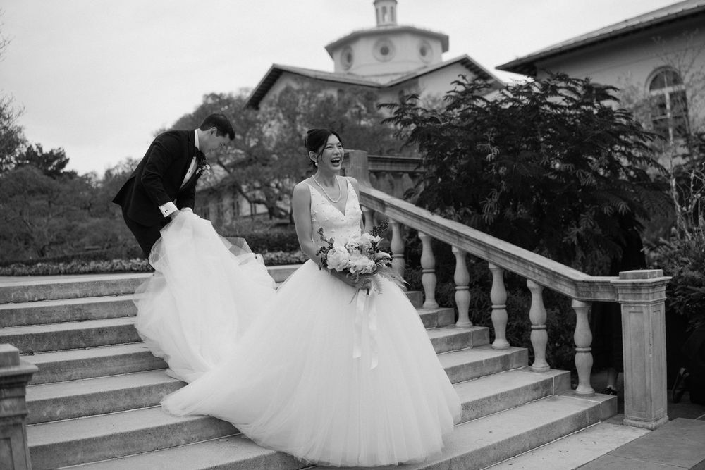 Wedding couple photographed in dramatic black and white on elegant stone steps.