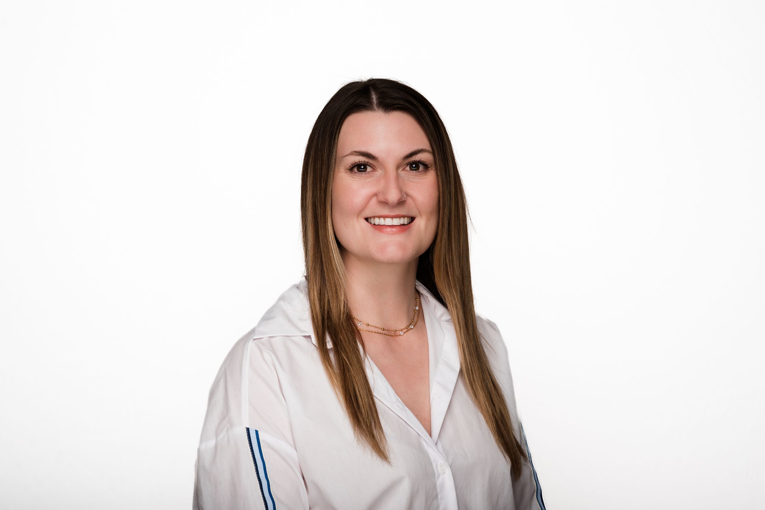 Professional portrait of a person in a white collared shirt against a white background.