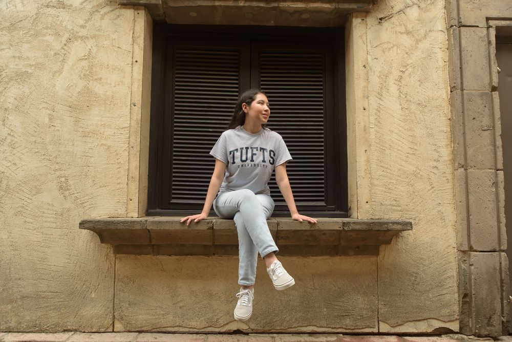 Tufts university future student sitting on ledge of window